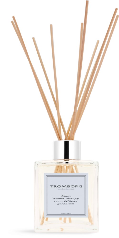 A glass bottle with sticks used as a diffuser for a pleasant scent. The label says "TROMBORG."
