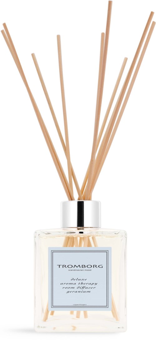 A clear glass bottle with wooden sticks emitting a scent, labeled TROMBORG and described as a candle or air freshener.