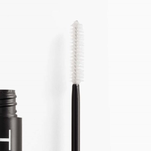 Et sort mascara rør med åbnet børste, viser hvid mascara børste. Enkel baggrund, fokus på makeup værktøjet.