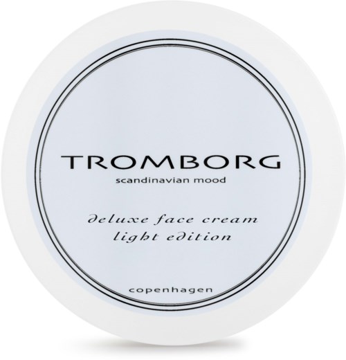 En hvid rund beholder med sort tekst, der annoncerer Tromborg hudpleje creme, let udgave, fra København.