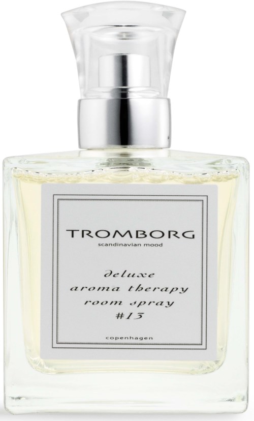 En klar glassparfymeflaske med sølvhode og hvit væske inni. Merket sier Tromborg deluxe aroma therapy.