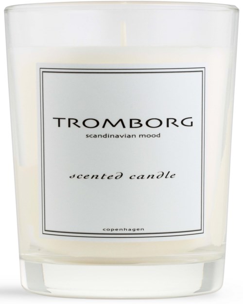 Ett vitt doftljus i en tydlig glasbehållare med en enkel etikett. Etiketten säger "Tromborg" och "scandinavian mood."