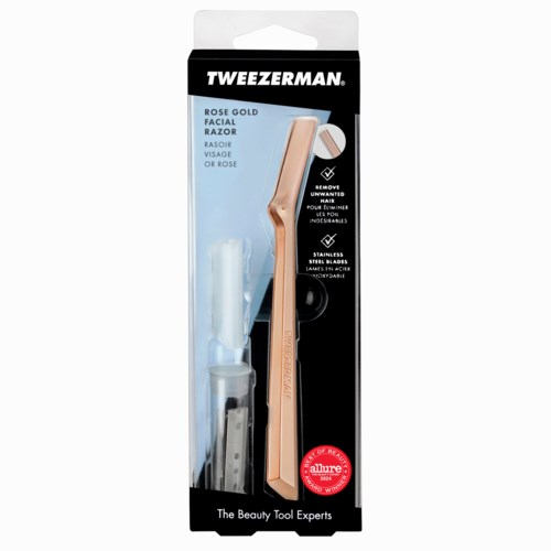 En roséguldfacialrakhyvel med skyddande lock i svart och vitt förpackning, märkt Tweezerman och påstår ta bort oönskat hår.