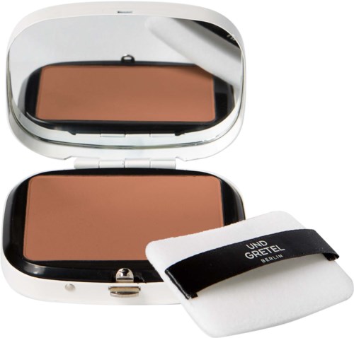 A compact with a mirror, pressed powder, and a small cloth for makeup touch-ups.