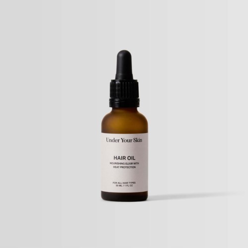 En liten bruna glasflaska med svart droppkork, märkt 'Hair Oil' för närande hår. Enkel design.