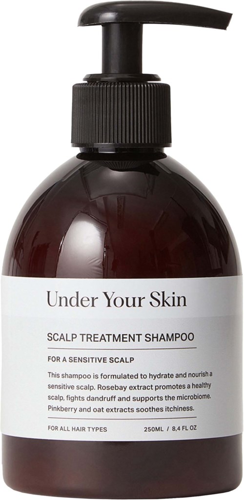 En mörkbrun flaska med svart pump märkt "Under Your Skin" schampo för känslig hårbotten.