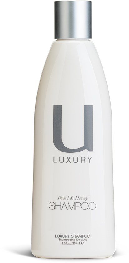 En vit schampoflaska med silverlock, märkt 'U LUXURY' och 'Pearl of Honey.'