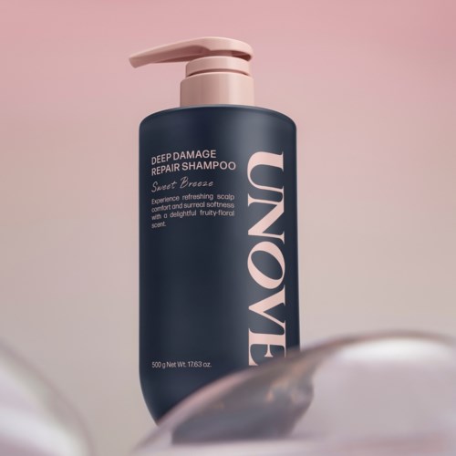Een donkerblauwe shampoo fles met roze pomp, met de tekst 'UNOVE' en productdetails.