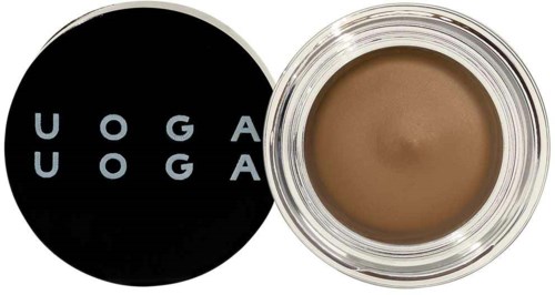 En rund spand med brunt makeup og sort låg, der siger UOGA UOGA.