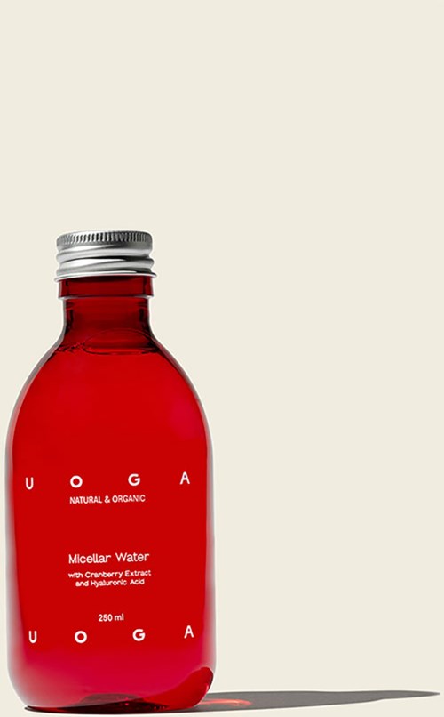 A red bottle labeled "Micellar Water" with a metal cap and a white background.