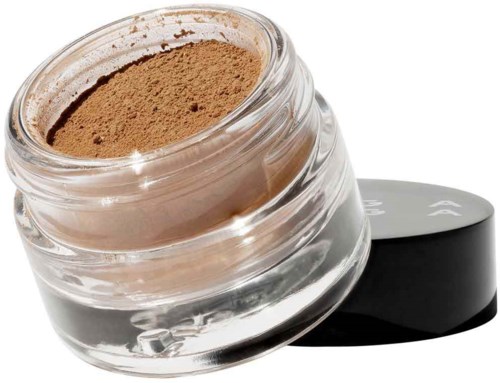 En liten glasburk med beige puder och svart lock bredvid.