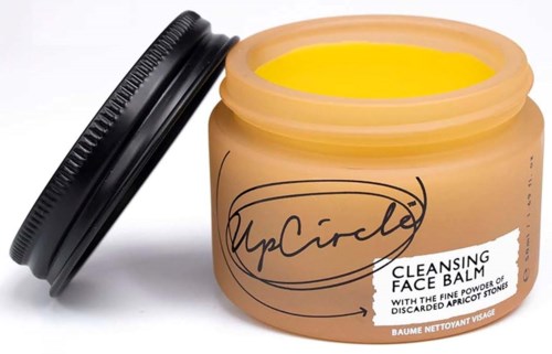 A jar of face balm labeled "MyCirkle" with a black lid, containing cleansing face balm with apricot stones.