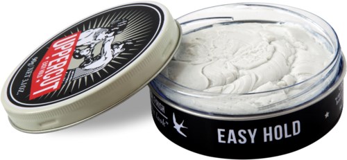 Een ronde open container met haarstylingsproduct, label en losse deksel.