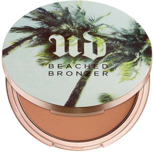 En kompakt med palmer på locket, märkt 'Beached Bronzer' med en logo i mitten.