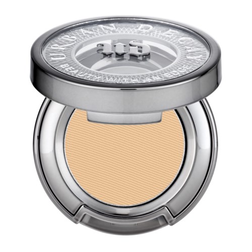 Ein kleines Makeup mit beigem, gepresstem Puder, silbernem Gehäuse und einem reflektierenden Deckel mit eingraviertem Text.