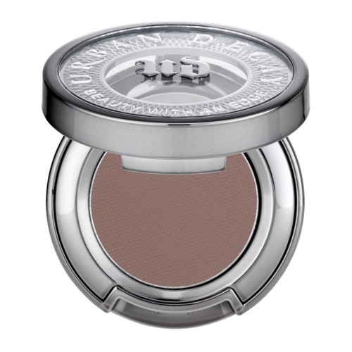 Ein runder Compact mit einem silbernen Deckel, enthält hellbraunes gepresstes Puder, wahrscheinlich Make-up.