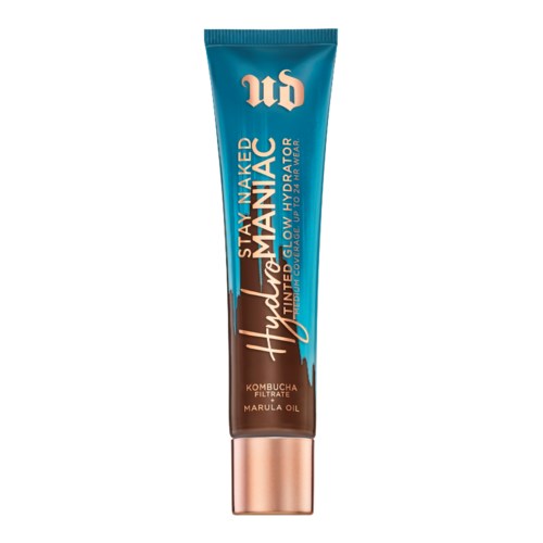 En tube med hudplejeprodukt med blå og brun emballage, mærket 'Stay Naked Hydamatte' med urter og marulaolie detaljer.