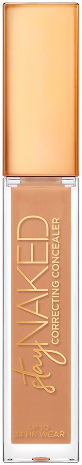 En foundationflaske med en ferskenfarvet kappe og etikette, mærket 'Stay Naked Correcting Concealer' i guld bogstaver.