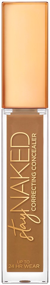 En makeupflaske med beige væske indeni, mærket 'Stay Naked Correcting Concealer', og en lys orange hætte.