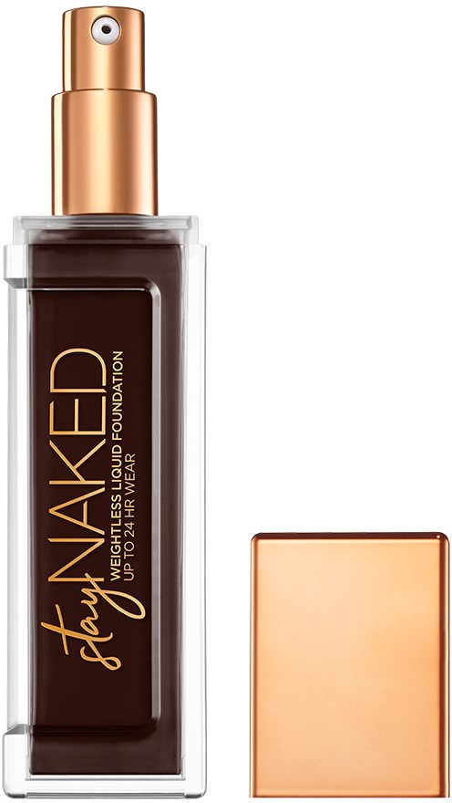 En flaska flytande foundation med sprayhuva, mörkbrun färg, och en roséguldfärgad lock. Produktnamnet står på flaskan.