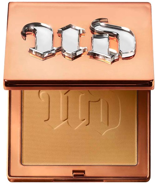 A compact case with a shiny lid that says '23D' and contains light yellow powder.