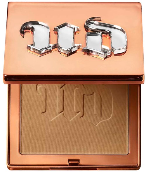 A compact with a peach-colored case and a logo: 3CE. The powder inside is a beige shade with embossed text.