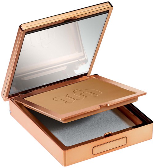 A compact makeup mirror with a built-in light, gold-colored case, and powder inside.