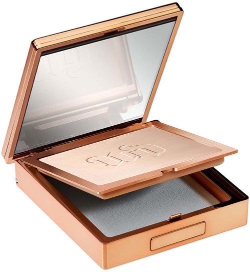 A rose gold makeup box with a large mirror inside, containing a pressed powder and a sponge applicator.