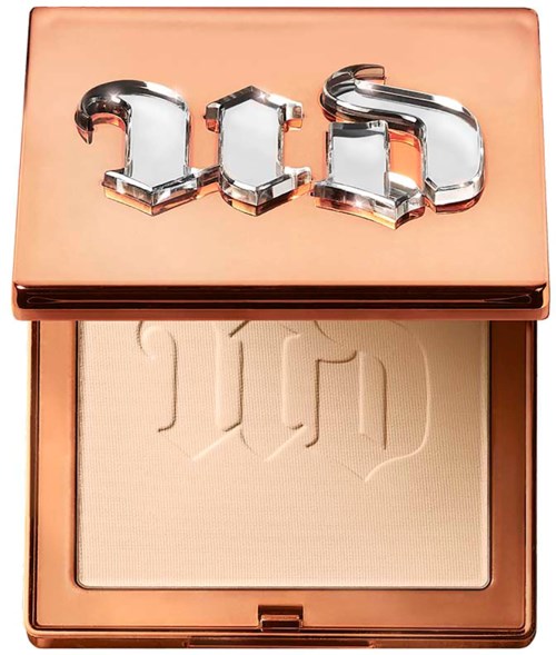A compact with a shiny rose gold lid and a beige powder inside. The lid has the word "Dior" in metallic letters.