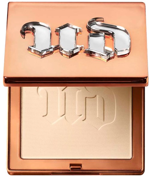 A compact makeup product with a shiny lid featuring the brand name and a light-colored powder inside.