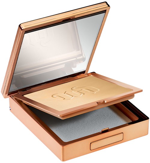 A makeup compact with a mirror, peach-colored exterior, and a sponge applicator inside.