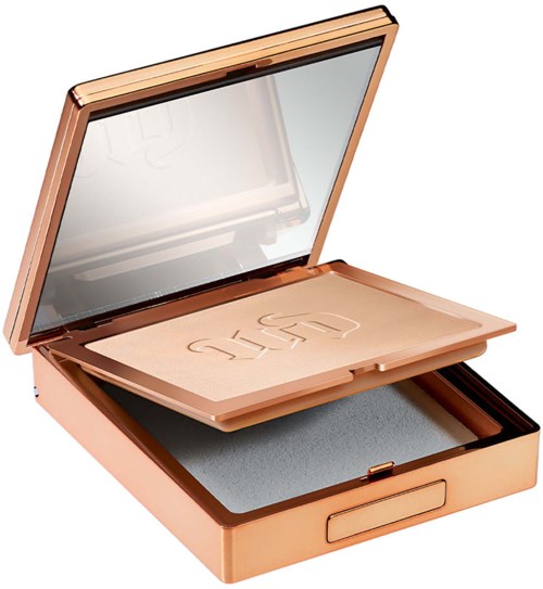 A rose gold makeup compact with a mirror, pressed powder, and a sponge inside.