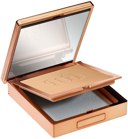 A makeup compact with a mirror, bronzer, and a sponge inside the rose gold case.