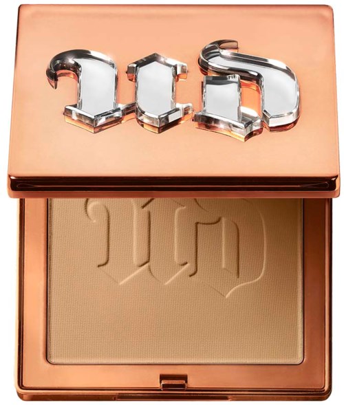 A makeup compact with a beige powder and a shiny lid decorated with the word 'Dior' in 3D letters.