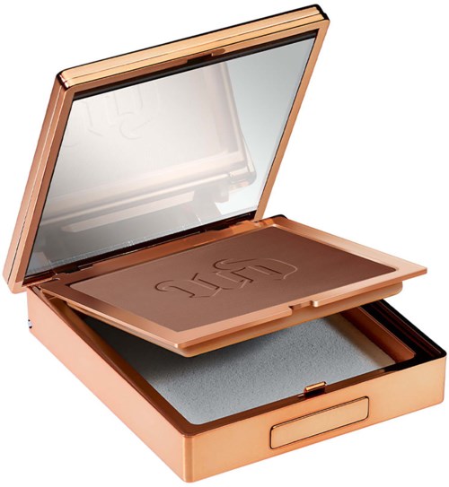 A makeup palette with a mirror inside a rose gold case, containing multiple shades of eyeshadow.
