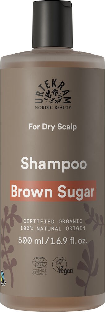 En brun flaske med svart cap for tørt hodebunns sjampo. Den har merker om økologiske, veganske og naturlige ingredienser.