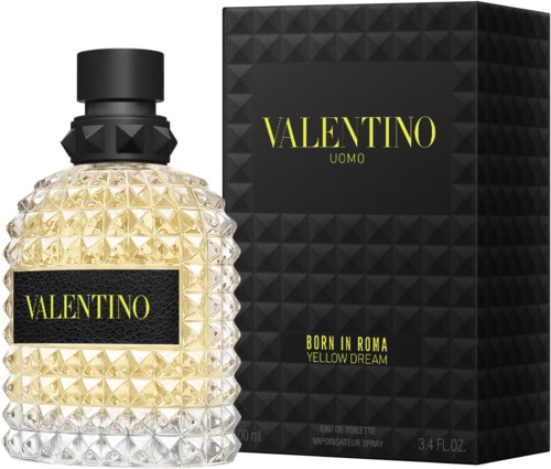 En parfymeflaske med teksturert glass og svart lokk, ved siden av en svart eske med gul tekst som promoterer Valentino herreduft.