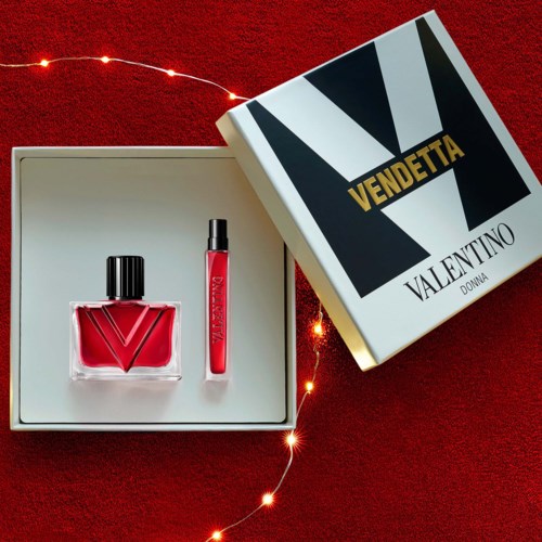 Röd läppstift och nagellack i en vit box på en röd yta, med en Valentino Vendetta-box i närheten.
