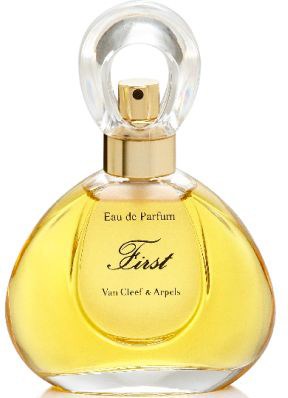 En parfymeflaske med klart, rundt lokk og gulldetaljer, fylt med gul væske, merket 'First' av Van Cleef & Arpels.