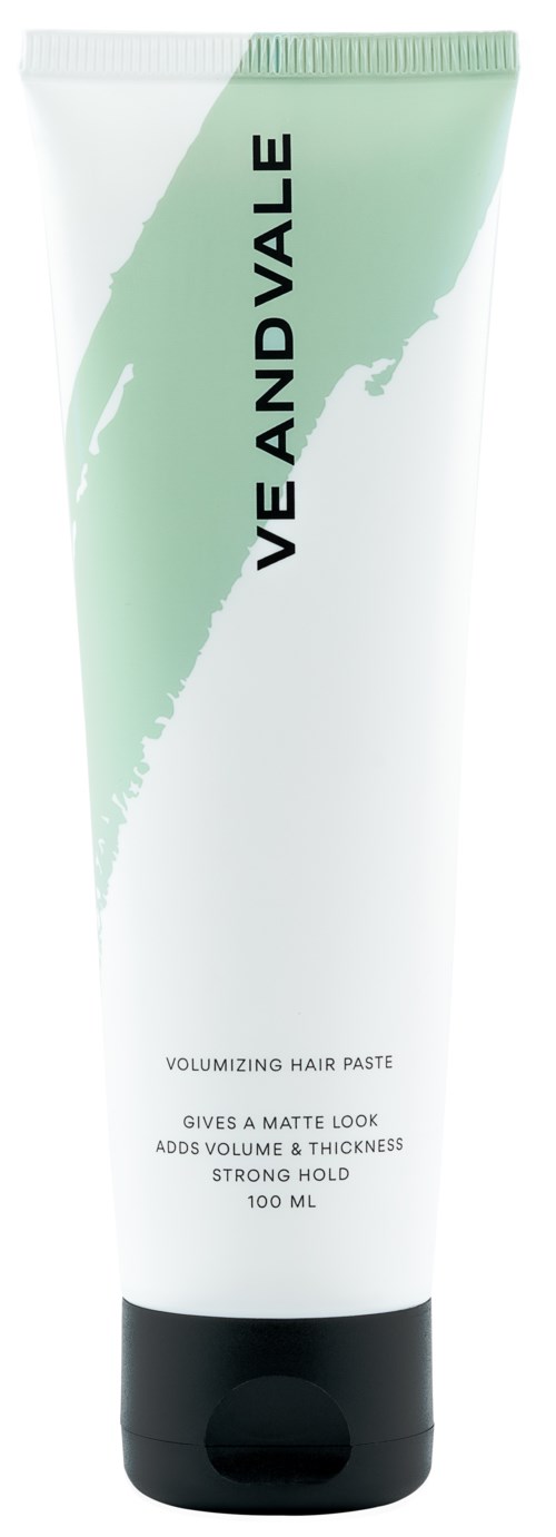 En vit tub med grön och svart text, märkt 'Volume and Value' och 'Volumizing Hair Paste'.