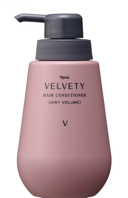 En lyserød flaske med mærket Velvety Hårbalsam med sort pumpehætte.