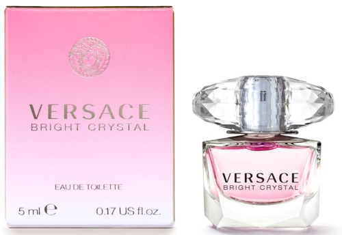 Parfumsiru ja pinkki lahja sen vieressä. Laatikossa lukee "Versace Bright Crystal" ja pullo on kirkas ja kalliintai iluinen.