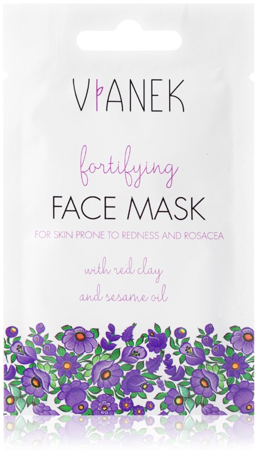 En hvit pakke med lilla blomster nederst, rosa og svart tekst, reklame for ansiktsmaske med naturlige ingredienser.