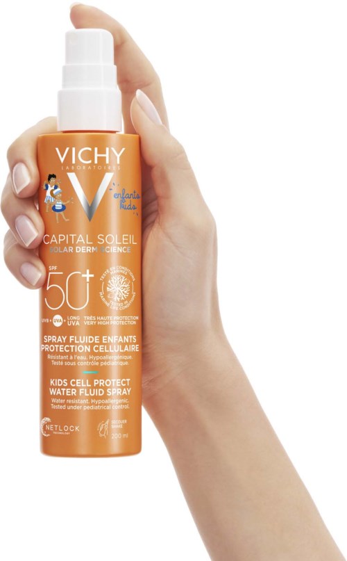 A hand holds an orange bottle of Vichy sunscreen with SPF 50+ for kids protecting against sun. Simple design and spray.