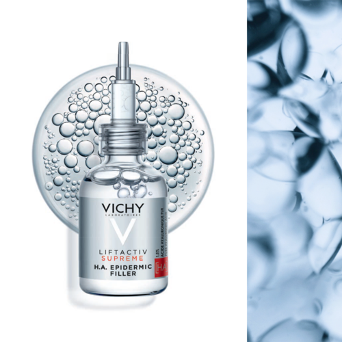 En Vichy hudvårdsprodukt med pipett, omgiven av bubblor, framför en cirkulär bakgrund och en blå texturerad sektion.