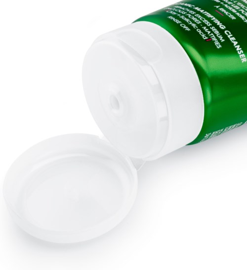 En grön flaska med vit lock, sannolikt ett rengöringsmedel, med locket avlägsnat och bredvid.