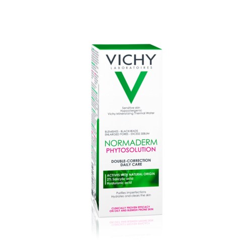 En vit förpackning med grön och svart text, visar Vichy-logotyp och produktnamn för hudvård. Grönt hjärtformat märke.