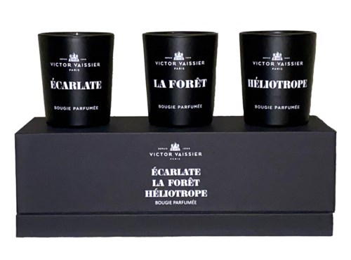 Drie zwarte geurkaarsen in een doos, gelabeld met geurkleuren: Écarlate, La Forêt, Héliotrope.
