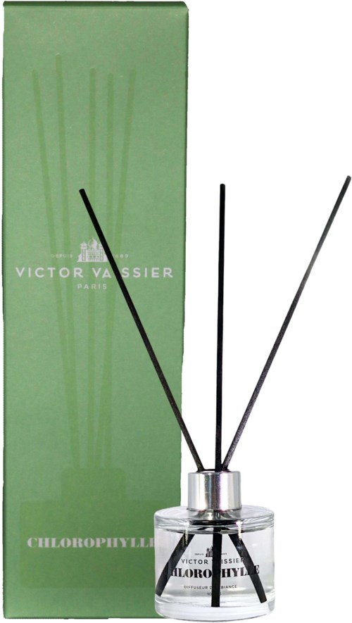 Een parfumfles met zwarte en witte stokjes voor een groene doos met witte tekst, gelabeld Victor Vassier.
