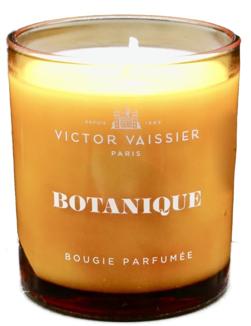 Een gele geurkaars in een glazen pot met witte tekst, gemerkt "BOTANIQUE" door Victor Vaissier, Parijs.